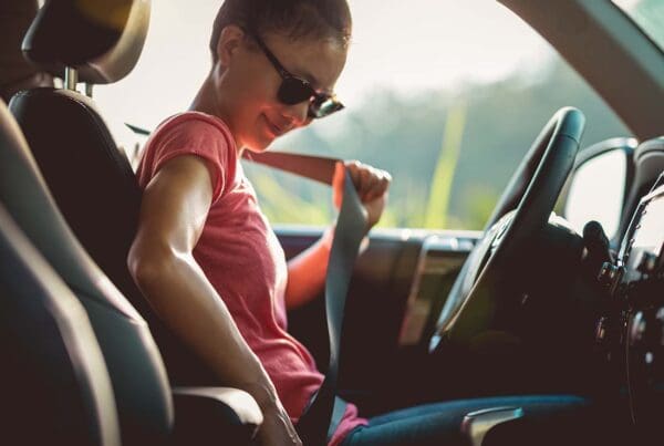 It’s Your Turn to Earn Rewards - Young Woman Driver Buckling up Her Seat Belt Before Getting Ready to Drive Her Car on a Sunny Day at Sunset